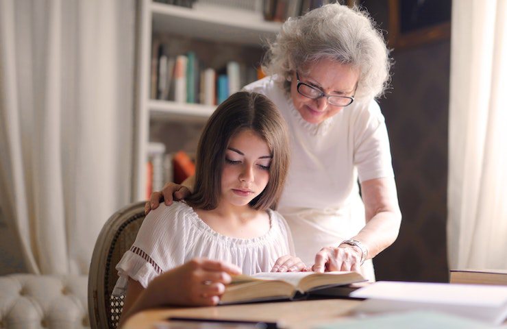 Signora anziana aiuta ragazza giovane durante lo studio