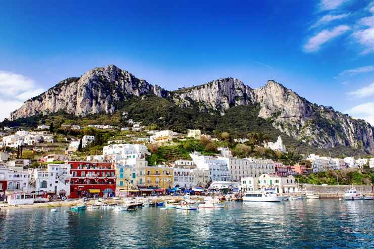 Visuale di un paese sulla costa del mare con montagne sullo sfondo