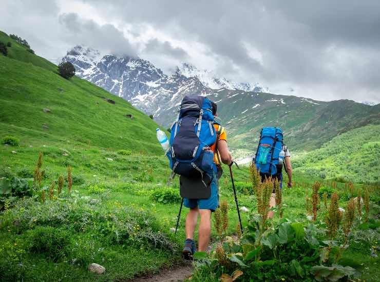 Escursionisti in montagna con cielo nuvoloso