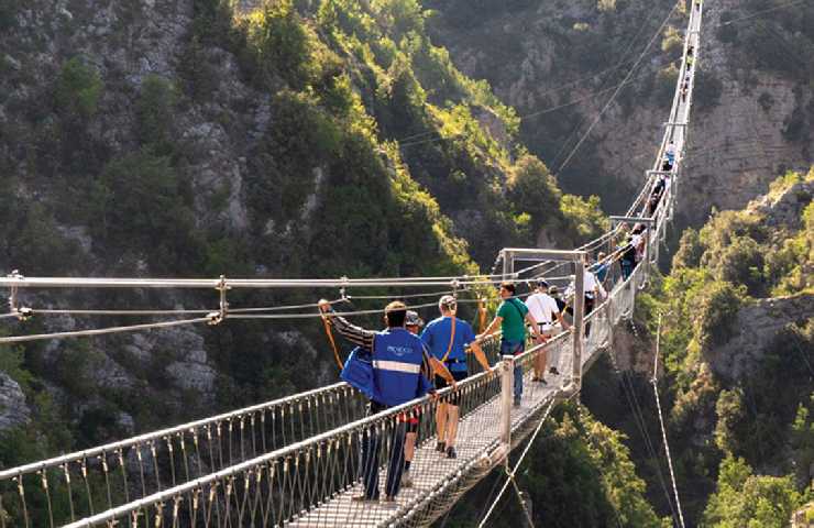 Turisti sopra al Ponte tibetano tra le montagne della Basilicata