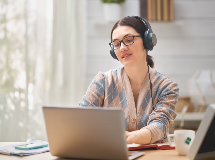 Una ragazza ascolta la musica con le cuffie davanti al pc