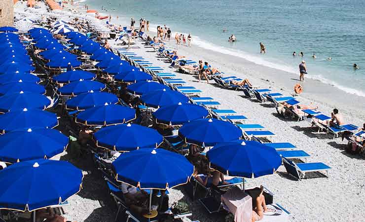 file di ombrelloni e lettini in una spiaggia attrezzata italiana