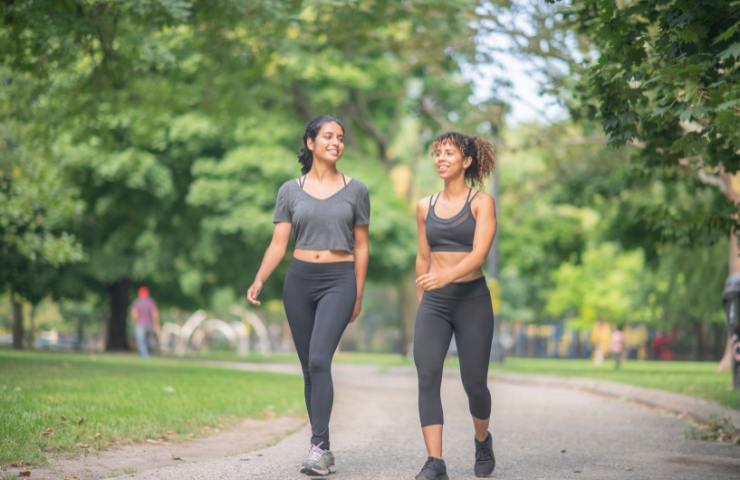 Due ragazze camminano in un parco