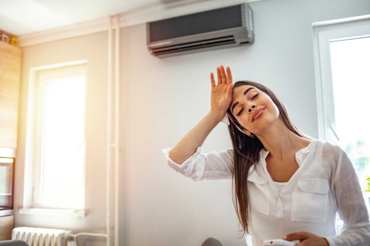 ragazza che sente caldo con condizionatore