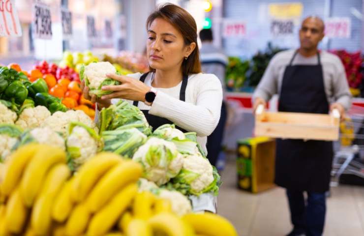 Donna che acquista la verdura al supermercato 